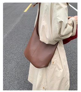 Detail aus dunkelbraunem Leder mit Lychee-Struktur an einer minimalistischen Hobo-Tasche