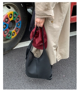 Nahaufnahme der schwarzen Tote-Bag aus genarbtem Leder zum lässigen Trenchcoat