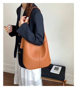 Modell mit großer karamellfarbener Hobo-Tasche aus Narbenleder für Beruf und Alltag