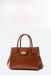 Close-up of vintage brown tote bag with pebble leather texture and gold oval lock