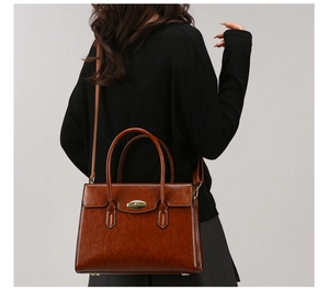 Detail of caramel tote bag showing vintage gold oval twist lock and smooth leather texture