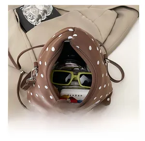 Intérieur spacieux d'un sac à bandoulière marron à pois montrant la capacité de rangement