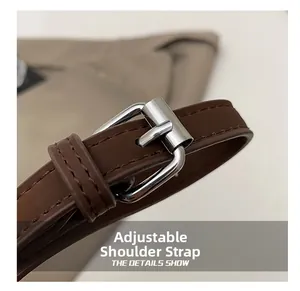Gros plan sur la bandoulière réglable en cuir marron foncé avec boucle en métal argent