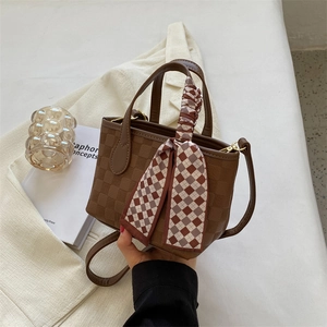 Brown checkered leather handbag with decorative scarf and adjustable crossbody strap