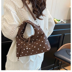 Détail du sac à bandoulière marron café à pois avec nœud papillon et pendentif