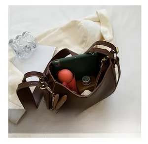 Spacious interior of a dark brown leather bag holding a tablet, umbrella, and water bottle