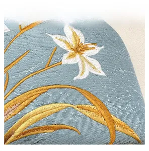 Detailed macro view of premium blue floral embroidery with gold leaves on this bag