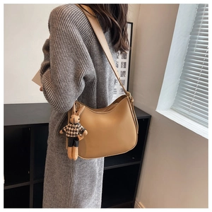 Detail of camel crescent shoulder bag with adjustable strap and cute rabbit plush charm