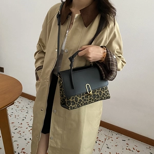 Chic leopard print handbag with black leather flap and gold U-shaped metal buckle detail