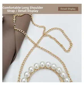 Detail of elegant gold chain strap and large white pearls on a minimalist handbag