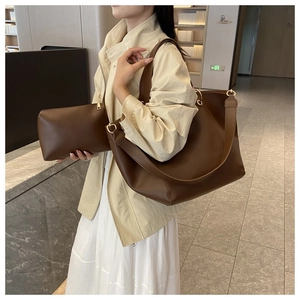 Détail du sac seau marron rétro et sa pochette assortie avec zips dorés chics