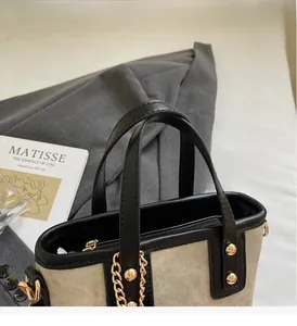 Detailansicht der Canvas-Eimertasche mit schwarzen Ledergriffen und goldenen Nieten