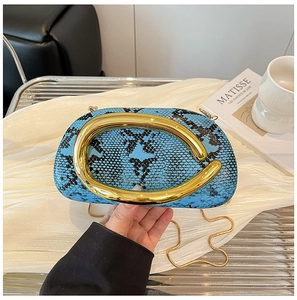 Detail of blue python pattern faux leather handbag with golden snake chain and handle
