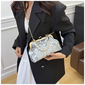 Detail of vintage French bag with floral patterns, pearl handle and gold chain strap