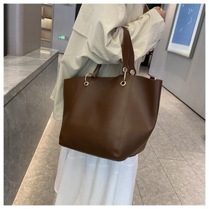Détail du grand sac cabas en cuir marron foncé avec anneaux dorés et intérieur spacieux