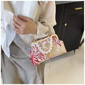 Detailed view of vintage embroidery handbag with pearl handle and golden chain strap
