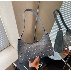 Détail du sac hobo en denim bleu avec clous argentés et style vintage Y2K