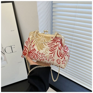 Close-up of vintage embroidered floral clutch bag with a golden metal chain strap