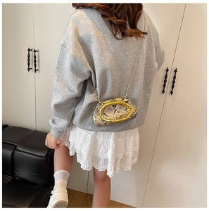 Detailed view of snake texture finish with prominent gold metallic C-shape buckle hardware