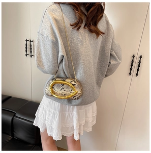 Detailed view of animal print shoulder bag featuring a large polished gold oval buckle