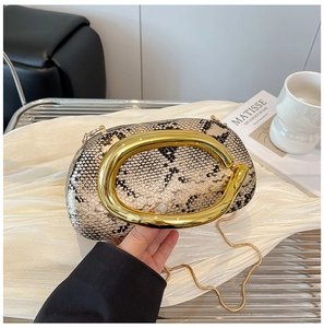 Detail of acrylic snake pattern handbag with round gold handle and metal chain