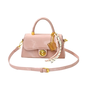 Sac à main en cuir verni rose avec breloque raquette de tennis dorée et bandoulière