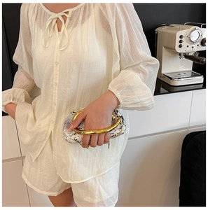 Detail of semi-sheer white two-piece set featuring textured long sleeve top and shorts