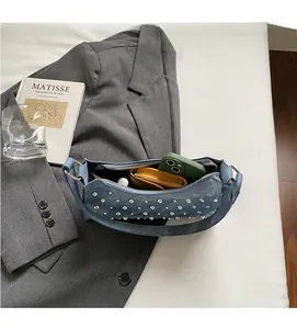 Sac à bandoulière en denim bleu avec rivets montrant l'intérieur spacieux et les objets