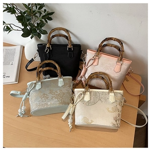 Detail of four embroidered bucket bags with bamboo handles and elegant pearl charms