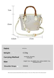 Detail view of embroidered bucket bag with bamboo handle and floral pattern textures