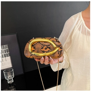 Detail of vintage snake skin texture clutch bag with large oval gold metal handle