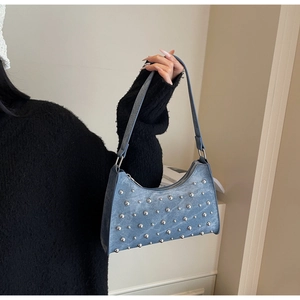 Vue détaillée du sac hobo en jean bleu avec rivets argentés et finitions métalliques