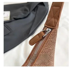 Detail of high-quality silver zipper and leather strap on brown canvas tote bag