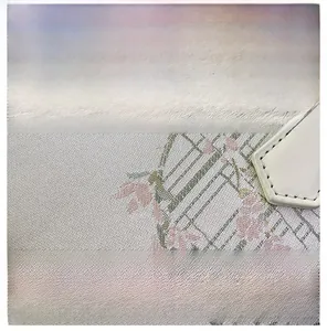 Macro detail of refined floral embroidery and stitching on off-white bucket bag