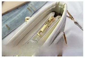 Close-up of premium golden metal zipper detail on embroidered bucket bag with vintage pattern
