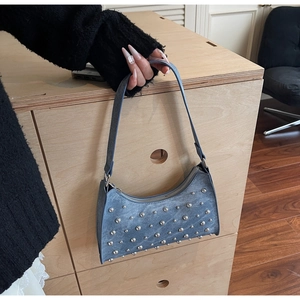 Détail d'un sac à main bleu vintage avec rivets argentés et finition mate pour femmes