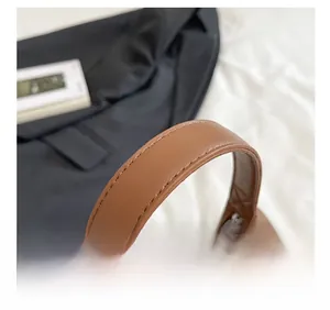 Detail showing high-quality stitching and durable leather strap on the brown shoulder bag