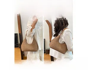 Detail view of brown textured half-moon bag showing handheld and shoulder carrying styles