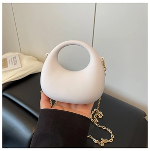 Dettaglio borsa a mezzaluna bianco opaco con manico rotondo e catena dorata