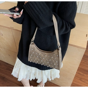 Gros plan d'un sac sous le bras en cuir marron vintage avec des rivets argentés