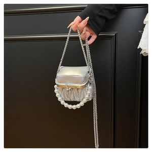 Detail of silver pleated mini bag featuring a pearl handle and slim chain strap