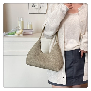 Detail view of the textured khaki hobo bag with seamless zipper and minimalist shoulder strap