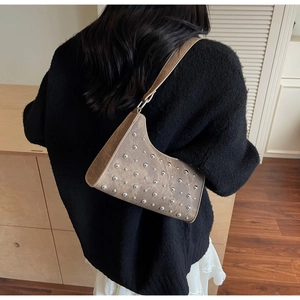 Détail du sac porté épaule vintage marron avec rivets argentés sur cuir texturé