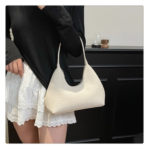 Chic hobo shoulder bag in cream white styled with a minimalist outfit and lace skirt