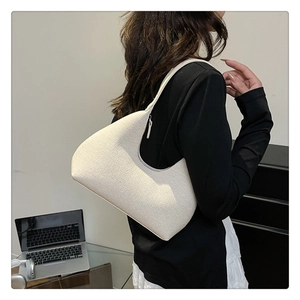 Detailed texture of cream-colored hobo bag with grain leather and slim shoulder strap