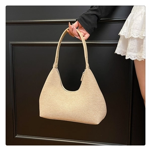 Detail of beige hobo bag showing woven texture and smooth synthetic leather strap