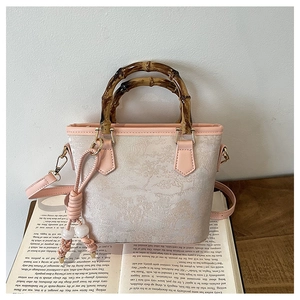 Detail of bamboo handle and pink jacquard fabric with chic tassel on the bucket bag