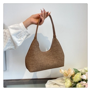 Detailed view of brown textured tweed hobo bag with leather handle and silver zipper