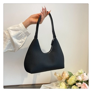 Detail of black textured fabric hobo bag with smooth leather strap and silver zipper