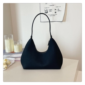 Detailed view of black litchi grain leather hobo bag with a zipper and shoulder strap